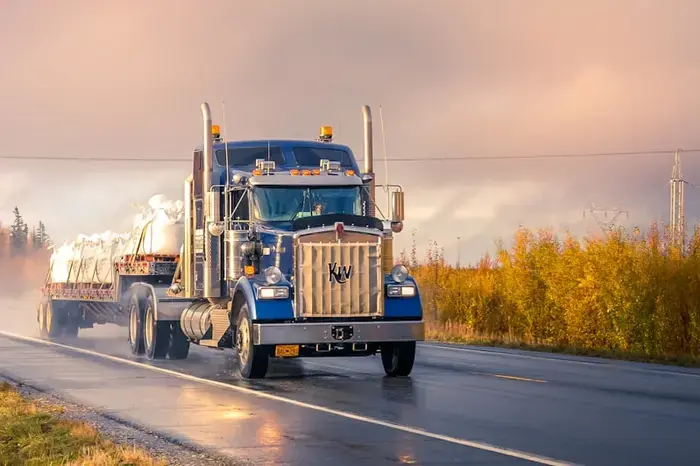 Semi truck on a wet highway at sunrise